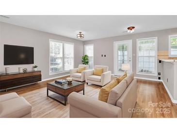 Bright living room features wood floors, large windows, and stylish modern furniture at 2045 Flushing Ct, Charlotte, NC 28215