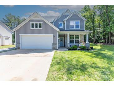 Charming two-story home featuring a well-maintained lawn, attached garage, and inviting front porch at 2902 Oakdale Rd, Charlotte, NC 28216