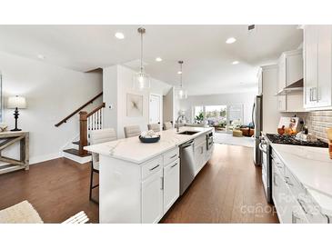 Bright, open kitchen boasts a large island with pendant lighting and stainless steel appliances at 330 Armour St # 46, Davidson, NC 28036