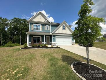Charming two-story home features a well-manicured lawn, a two-car garage, and inviting front porch at 348 Ox Bow Cir, Mount Holly, NC 28120