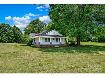 Charming single-story home featuring a brick foundation and a welcoming covered front porch at 5785 Nc 150 E Hwy, Denver, NC 28037