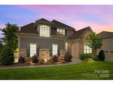 Charming two-story home featuring stone accents, a well-manicured lawn, and attractive landscaping at 6008 Candlestick Ln, Lancaster, SC 29720