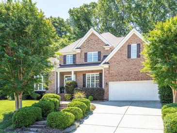 Charming two-story brick home featuring a well-manicured lawn and a spacious two car garage at 7040 Edenderry Dr, Charlotte, NC 28270
