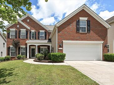 Charming two-story brick home with a well-manicured lawn and attached two-car garage at 9700 Ravenscroft Nw Ln, Concord, NC 28027