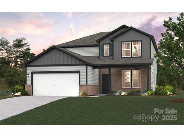 Charming two-story home features brick accents, gray siding, and a two-car garage at 9952 Manor Vista Trl, Kannapolis, NC 28027