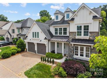 Charming two-story home with a combination of stone and white siding, dormer windows, and a two-car garage at 1012 N Sharon Amity Rd, Charlotte, NC 28211