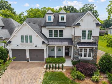 Beautiful two-story home featuring a stone and siding facade, dormer windows, and a two-car garage at 1012 N Sharon Amity Rd, Charlotte, NC 28211
