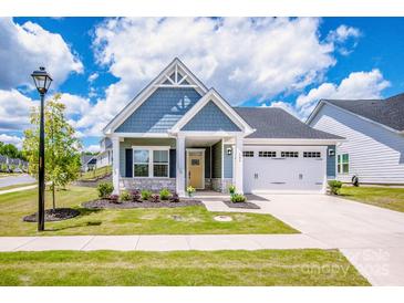 Charming single-Gathering home boasts a manicured lawn, attached two-car garage, and inviting front porch at 105 Chase View Ln, Troutman, NC 28166