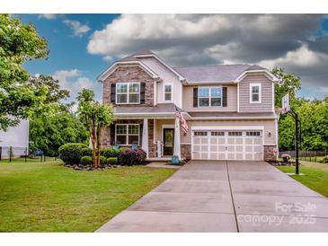 Charming two-story home boasts stone accents, a well-manicured lawn, and a spacious two-car garage at 130 Bay Laurel Dr, Mooresville, NC 28115