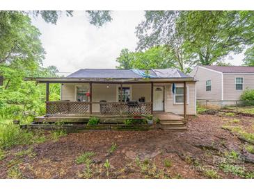 Exterior view of the house featuring a front porch with worn and stained features and landscaping in need of care at 1908 5Th St, Statesville, NC 28677