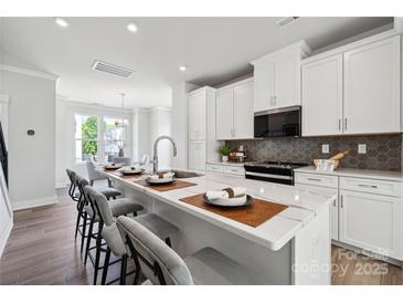Modern kitchen featuring white cabinets, a marble island with seating, and stainless steel appliances at 2009 Clarksdale Dr # 39, Charlotte, NC 28206