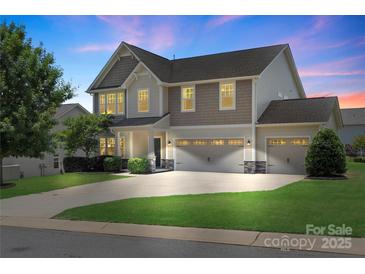 Charming two-story home features a three-car garage, manicured lawn, and inviting curb appeal at 3211 Gilroy Dr, Fort Mill, SC 29707