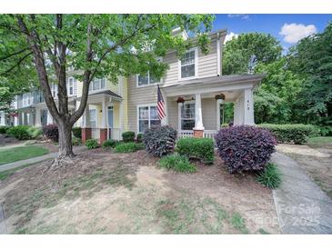 Inviting townhome showcasing charming curb appeal with lush landscaping and an American flag at 413 Hurston Cir, Charlotte, NC 28208
