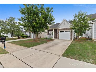 Charming brick and vinyl home with a well-manicured lawn and a two-car garage at 5076 Newport Lakes Dr, Rock Hill, SC 29732
