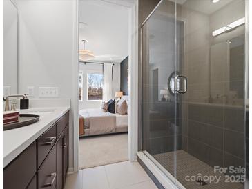 Modern bathroom featuring glass-enclosed shower and bedroom view with natural light at 5517 Swaling St, Charlotte, NC 28217