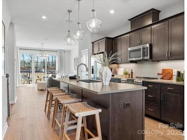 Modern kitchen featuring a spacious island with seating, stainless steel appliances, and open concept design at 5517 Swaling St, Charlotte, NC 28217