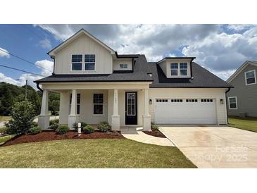 Charming two-story home with a two car garage, a manicured lawn, and beautiful landscaping at 13605 Tranquil Day Dr, Matthews, NC 28105