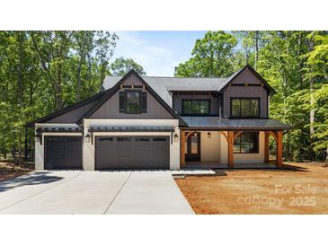 Stunning two-story home with a three car garage, modern farmhouse design, and covered front porch at 1408 Bloomsberry Ln, Waxhaw, NC 28173