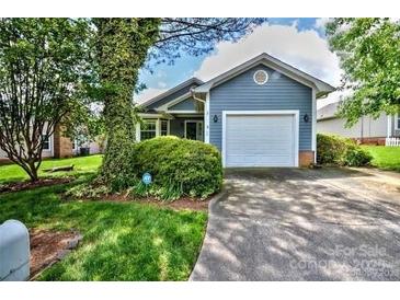 Charming one-story home featuring a blue exterior, a well-manicured lawn, and a paved driveway leading to an attached garage at 2915 Cherry Blossom Ct, Fort Mill, SC 29715