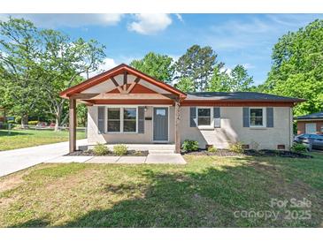 Charming single story home with a gray front door, brick exterior, manicured lawn, and gabled entry at 3932 Slagle Dr, Charlotte, NC 28215