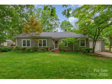 Charming single-story home with green lawn, mature trees, and inviting front porch at 408 Idlewood Dr, Kannapolis, NC 28083