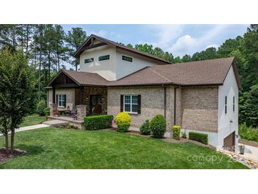 Beautiful brick home with well-manicured lawn and inviting front porch with stone and wood accents at 4616 Gold Finch Dr, Denver, NC 28037