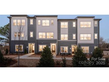 Modern townhome showcases a gray and white facade with multiple windows, offering ample natural light at 6013 Pivot Ct, Charlotte, NC 28205