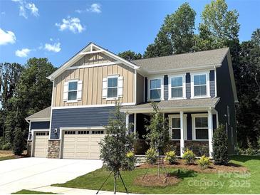 Charming two-story home featuring a three-car garage and manicured front yard at 9945 Cask Way, Huntersville, NC 28078