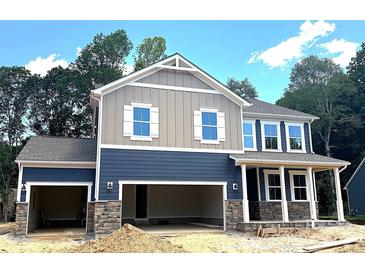 Charming two-story home featuring a two-car garage, stone accents, and a covered front porch at 9945 Cask Way, Huntersville, NC 28078