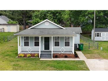 Charming single-story home with a welcoming front porch and well-maintained lawn and landscaping at 1004 Johnson St, Charlotte, NC 28206