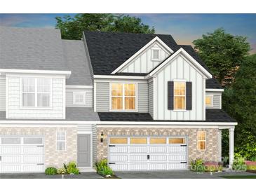 Charming two-story home featuring a brick veneer and white siding with black shutters over the garage at 2209 Cobble Ct # 212, Monroe, NC 28110