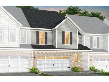 Charming home exterior featuring brick accents, white garage door, and inviting curb appeal at 2213 Cobble Ct # 214, Monroe, NC 28110