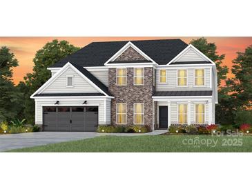 Charming two-story home featuring brick accents, a gray garage door, and a well-manicured lawn at 2218 Riverbend Ave # 23, Monroe, NC 28110