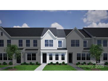 Attractive townhome featuring a gray roof, gray siding, and well-manicured lawn at 2906 Sloan Dr, Charlotte, NC 28208