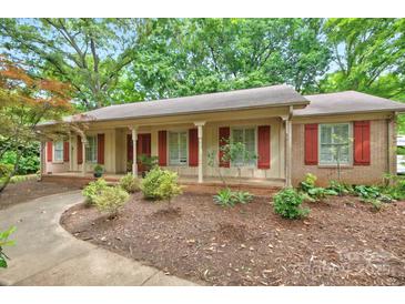 Charming single-story home boasts a well-maintained front yard with mature trees and inviting curb appeal at 3430 Rea Rd, Charlotte, NC 28226