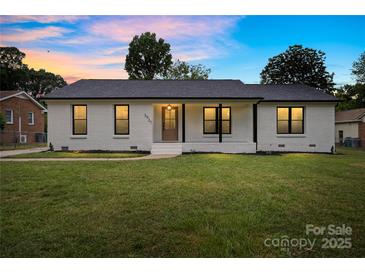 Charming white brick home featuring a well-manicured lawn and cozy front porch at 3937 Tamerlane Dr, Charlotte, NC 28205