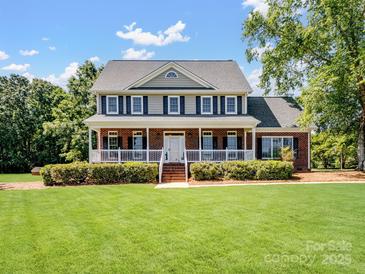 Beautiful two-story brick home with a welcoming front porch and manicured lawn at 4628 Dovefield Ln, Kannapolis, NC 28081