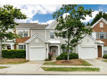 Charming townhome with a well-manicured lawn, attached garage, and inviting front entrance at 8040 Flanders St, Charlotte, NC 28277