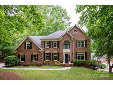 Stately two-story brick home with manicured lawn and mature trees offers timeless elegance at 8227 Lansford Rd, Charlotte, NC 28277