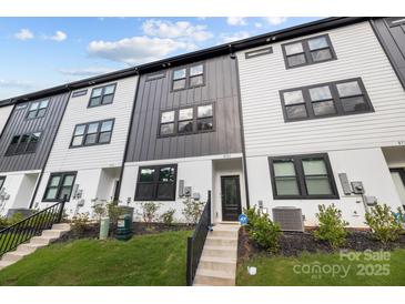 Modern townhome showcases black and white siding, black trim windows, and well-manicured lawn at 8723 Nolley Ct, Charlotte, NC 28270