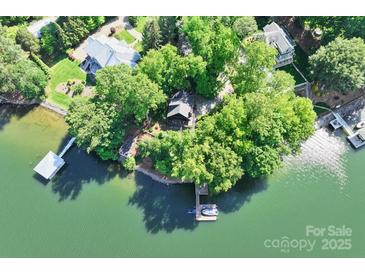 Stunning aerial view of lakeside home surrounded by lush greenery and private dock at 9289 Azalea Rd, Sherrills Ford, NC 28673