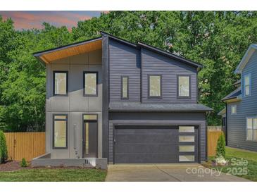 Modern two-story home with a gray exterior, attached garage, and minimalist landscaping for sleek curb appeal at 1711 Summey Ave, Charlotte, NC 28205