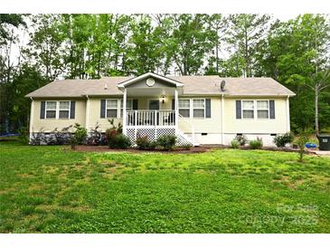 Charming single-story home featuring a covered porch and well-maintained front lawn with flower beds at 1821 Sherrer Rd, York, SC 29745