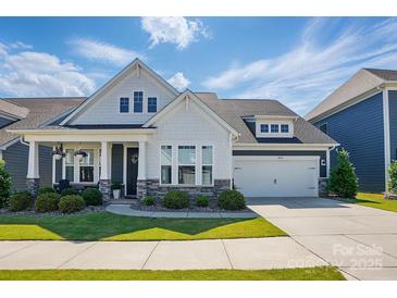 Charming two-story home with a manicured lawn, covered porch, and a two-car garage at 2062 Nellies Way, Fort Mill, SC 29715