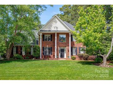 Charming two-story brick home featuring a symmetrical facade, white pillars, and lush green lawn at 3617 Ruth St, Indian Trail, NC 28079