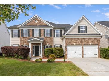 Charming two-story home with brick and siding, well-manicured lawn, and a two-car garage at 9647 Laurie Nw Ave, Concord, NC 28027