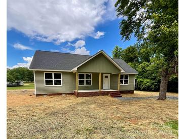 Charming single-story home with a covered porch and a well-manicured lawn in a serene neighborhood at 1050 Beaten Path Rd, China Grove, NC 28023