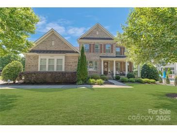 Charming two-story brick home with manicured lawn and inviting front porch at 11333 Preservation Ln, Charlotte, NC 28278