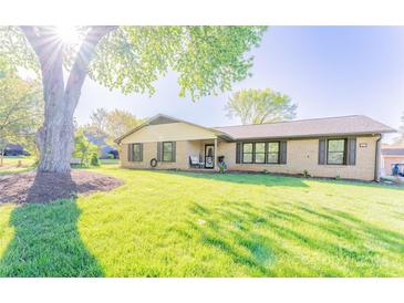 Charming brick home featuring a well-manicured lawn and mature shade tree at 125 Southwood Park, Mooresville, NC 28117