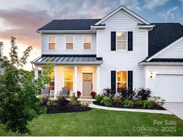Charming two-story home featuring a welcoming front porch and well-manicured lawn with tasteful landscaping at 1381 Regions Blvd, Fort Mill, SC 29707